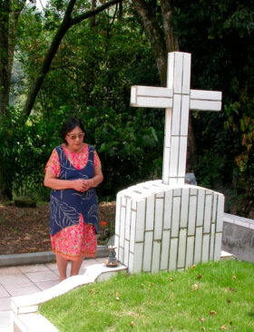 キユパナの丘の父の墓で祈る菊花さん（2004年筆者撮影）